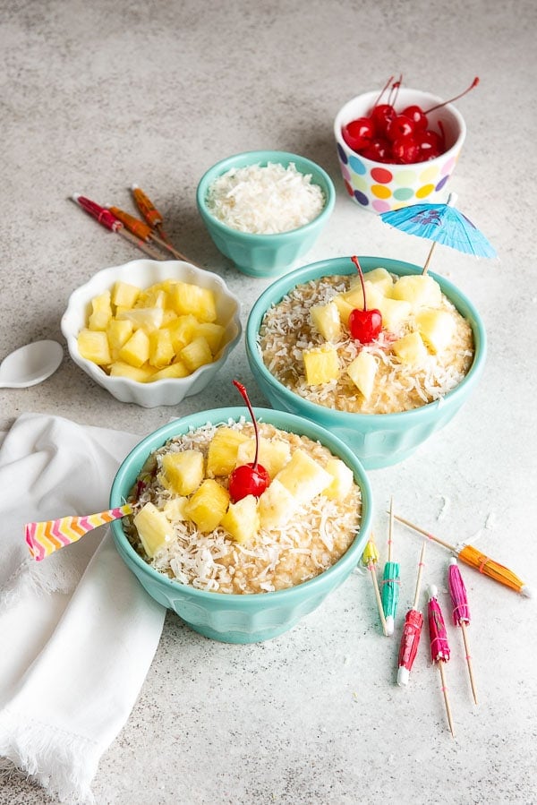 two servings of steaming hot Instant Pot Pina Colada Steel Cut Oats with tropical toppings