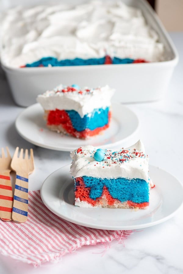 Two slices of Red White and Blue Cake with whipped cream frosting