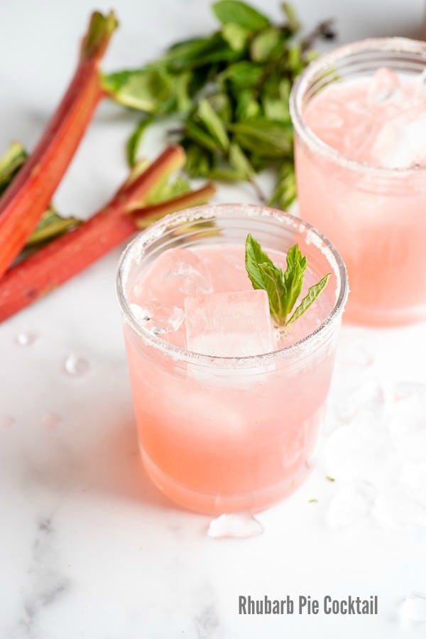 Refreshing, pink Rhubarb Pie Cocktail (a rhubarb vodka cocktail) with rhubarb in the background