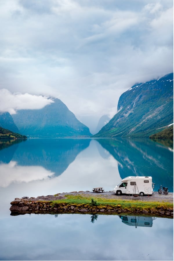 RV camping by a lake with mountains in the background