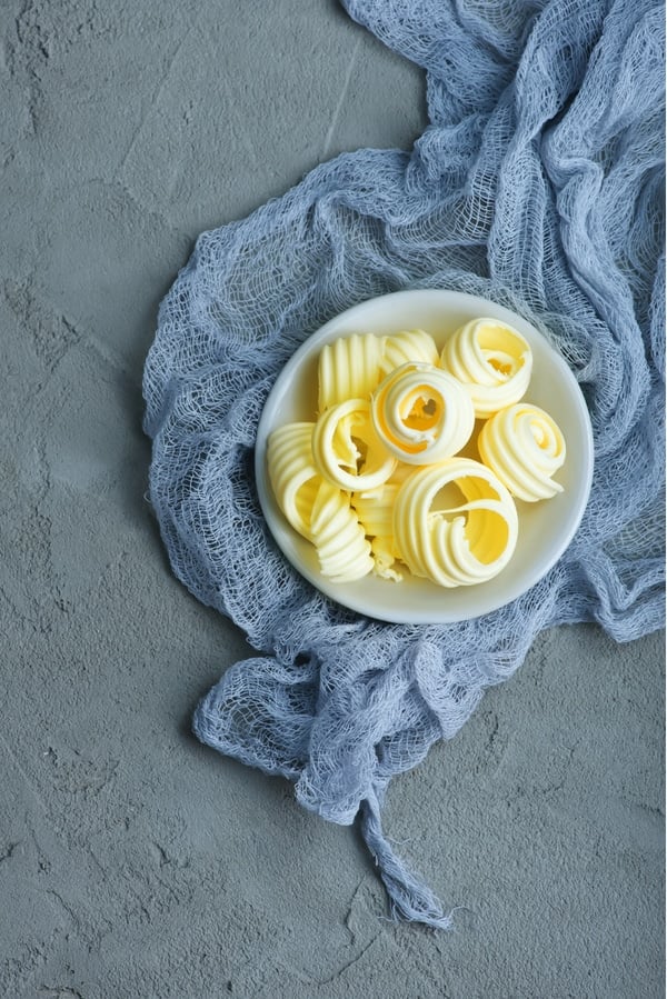 curls of butter on a small gray plate