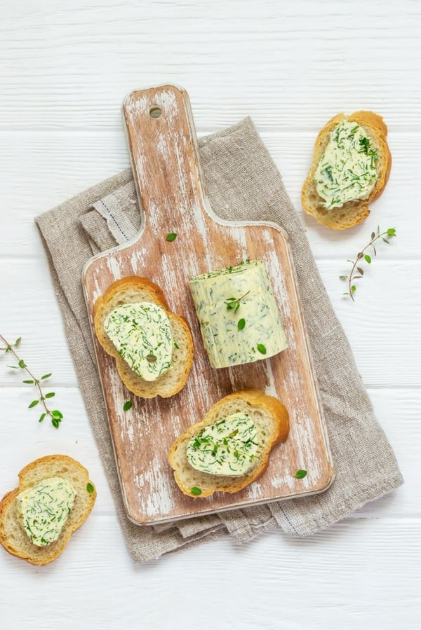 overhead of bread slices with herb butter log