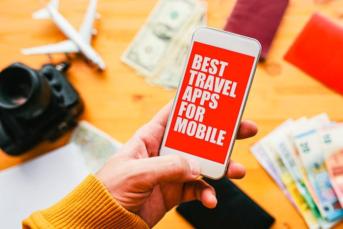 smart phone with 'best travel apps' in person's hand