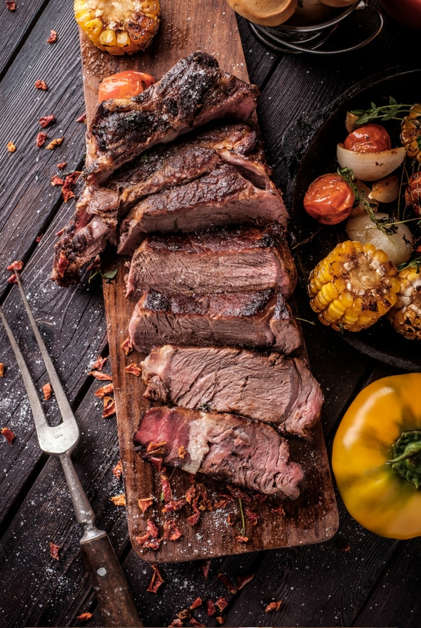 Sliced grilled steak on cutting board