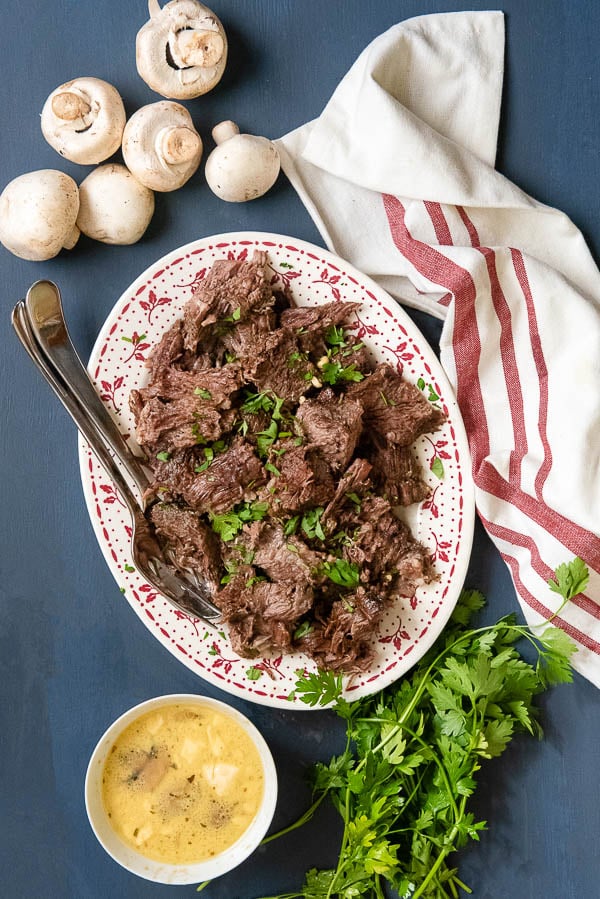 Creamy Mushroom Instant Pot Pot Roast recipe on vintage platter with sauce