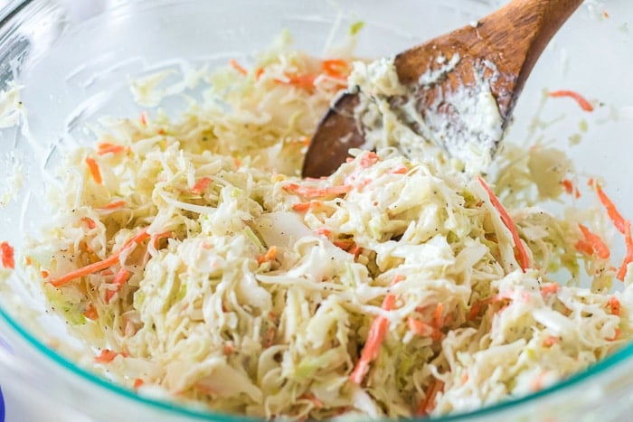mixing coleslaw in bowl with spoon