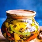 colorful roasted peppers in jar with oil and garlic.