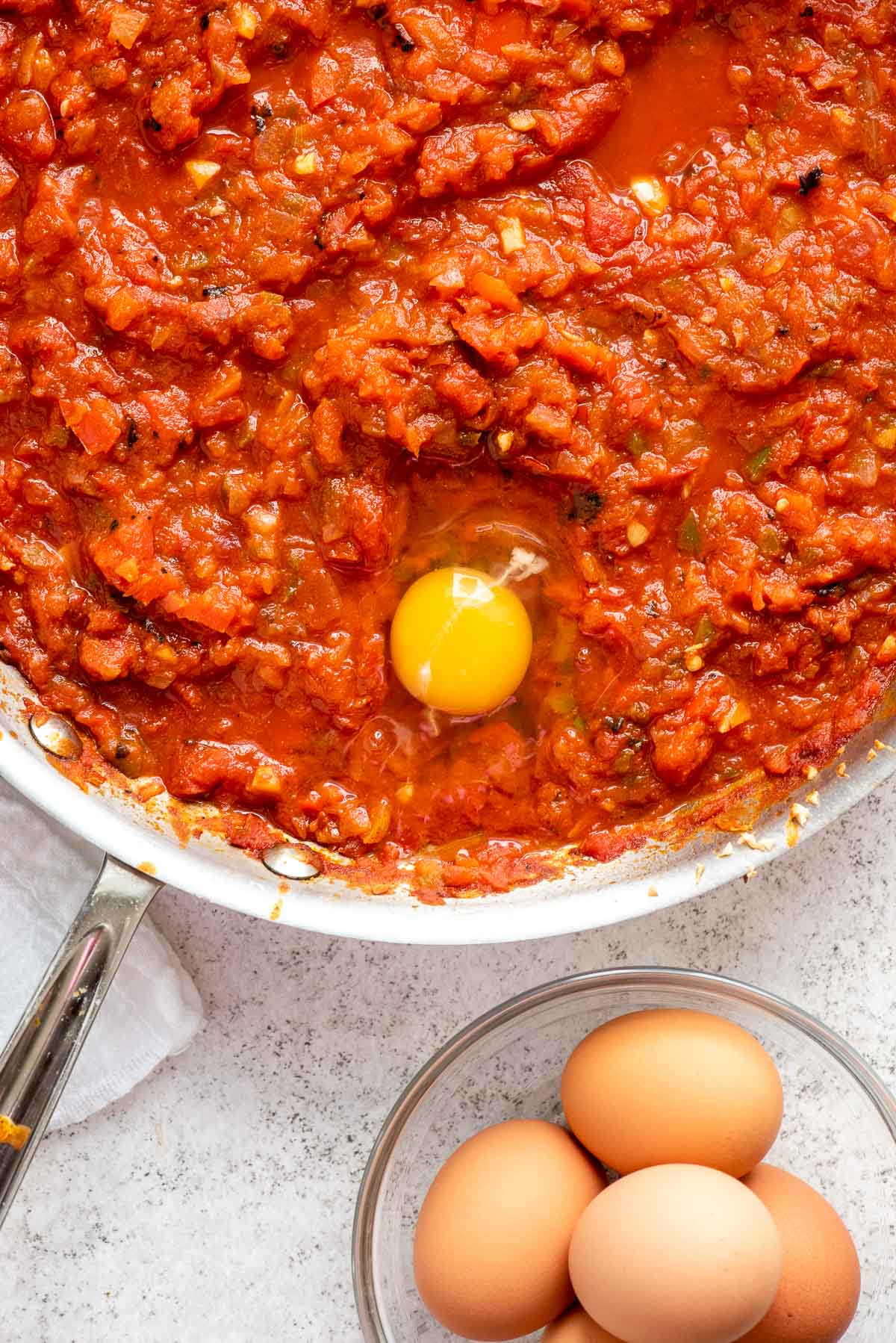 adding eggs to shakshuka 