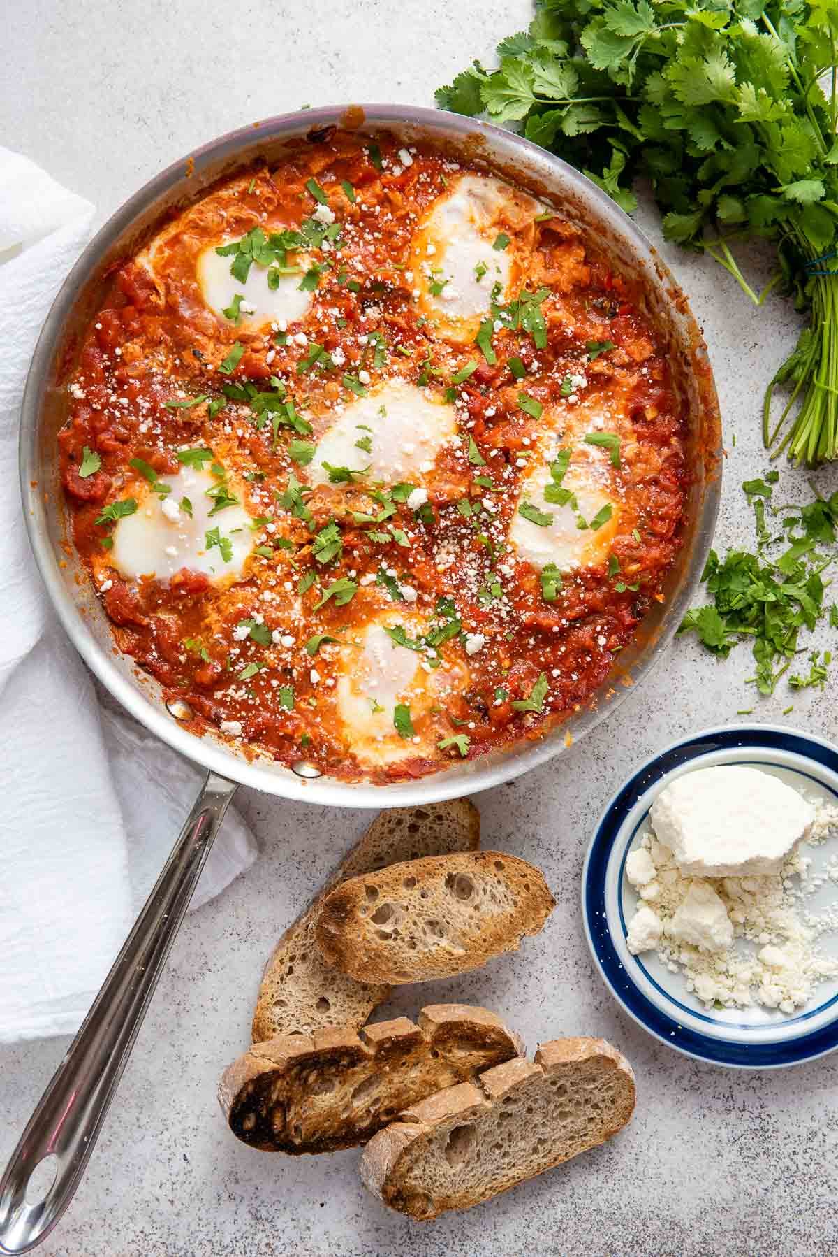 cooked shakshuka in skillet with bread 