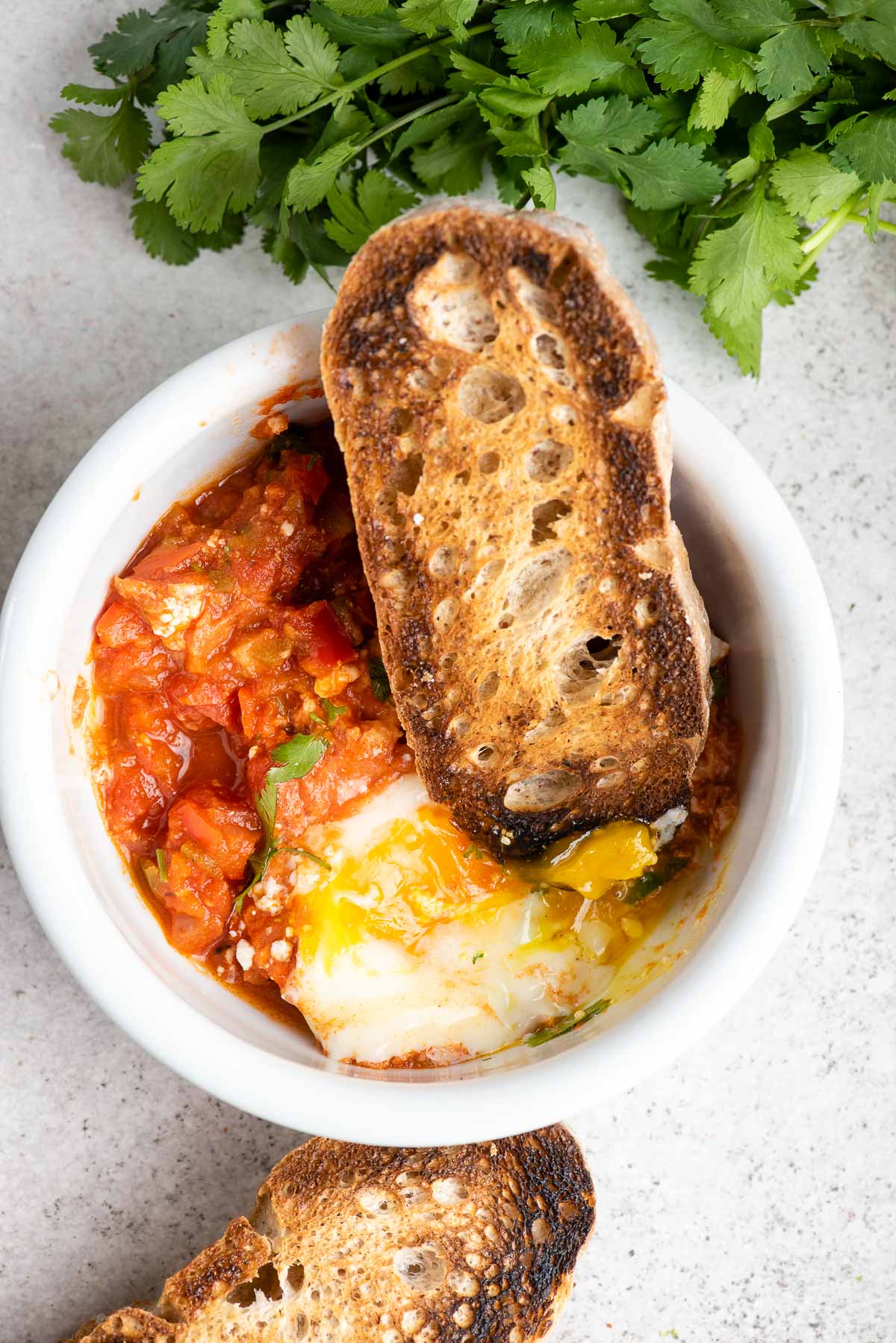 shakshuka in a bowl with bread slice