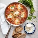 shakshuka in a skillet with crumbled cheese square image