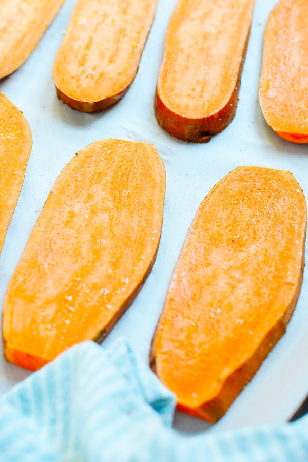 sliced sweet potatoes on a baking sheet