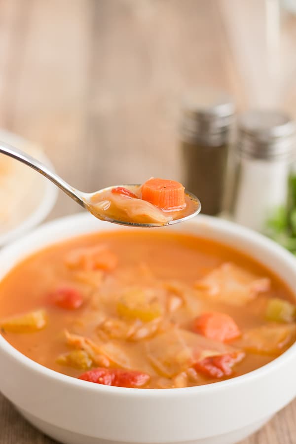 spoonful of cabbage soup over a bowl of the soup