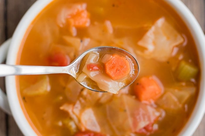 spoonful of vegetable soup over the bowl of soup