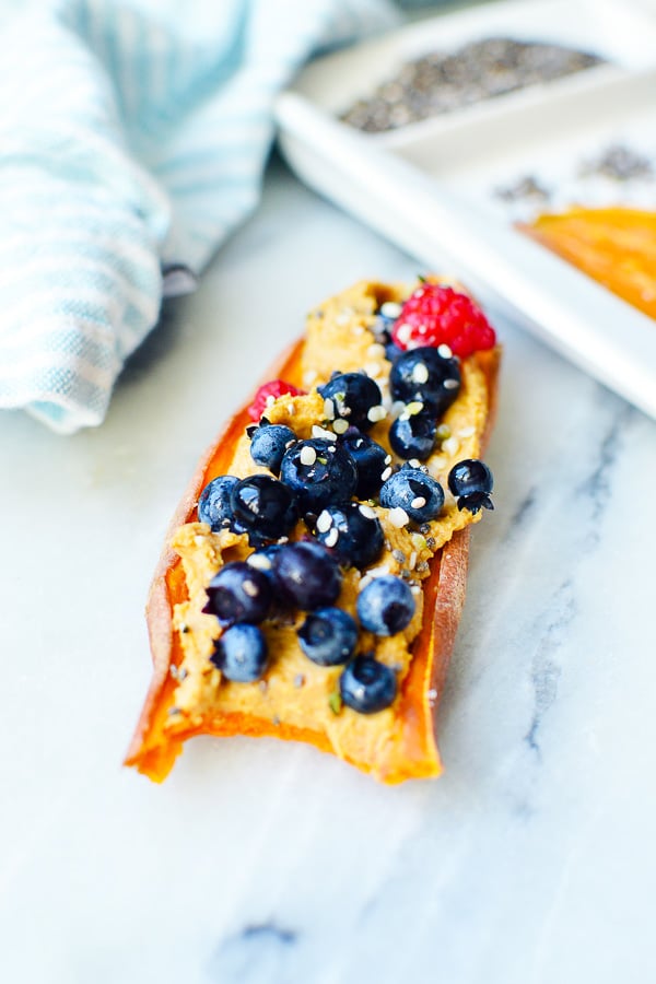 sweet potatoes toast with peanut butter, blueberries and bite taken