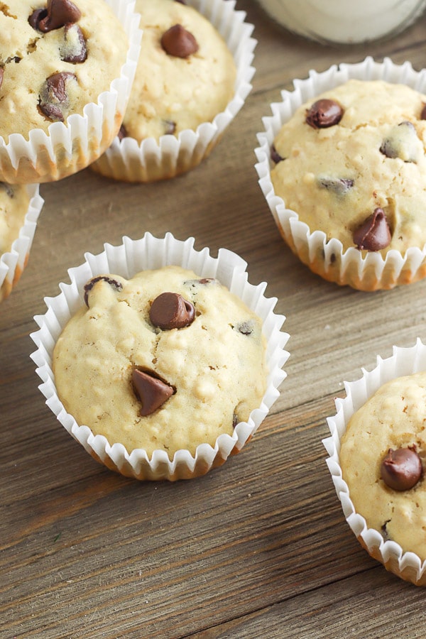 chocolate chip muffins in white liners on wood surface