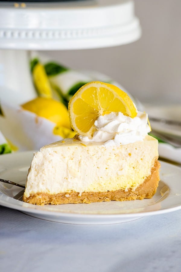 creamy cheesecake slice with whipped cream and lemon slices