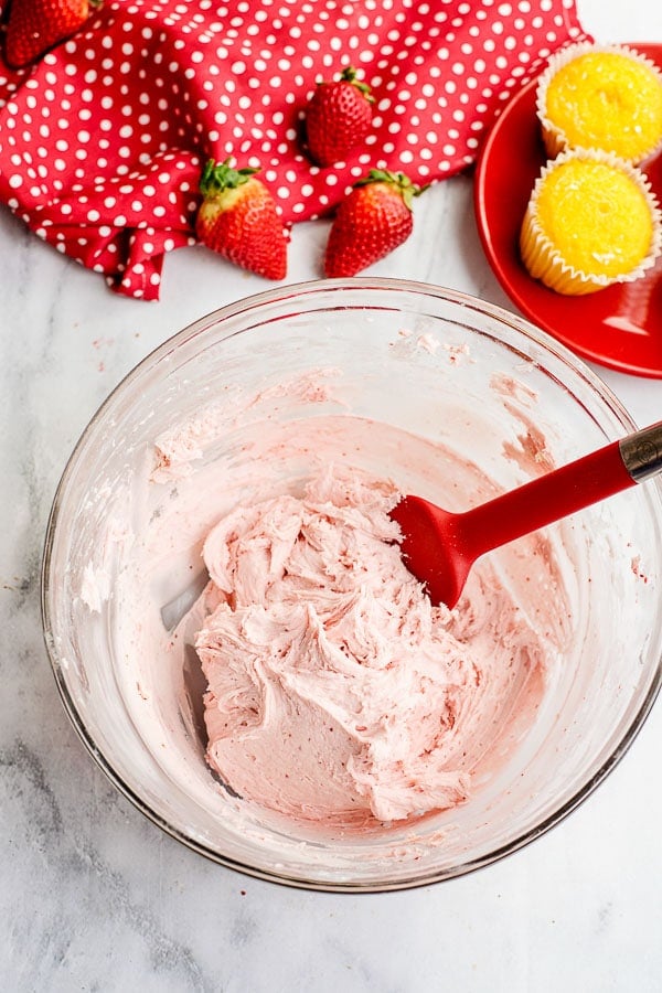 Strawberry Frosting in a mixing bowl with a spoon