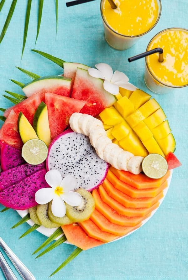 colorful platter of tropical fruit and smoothies