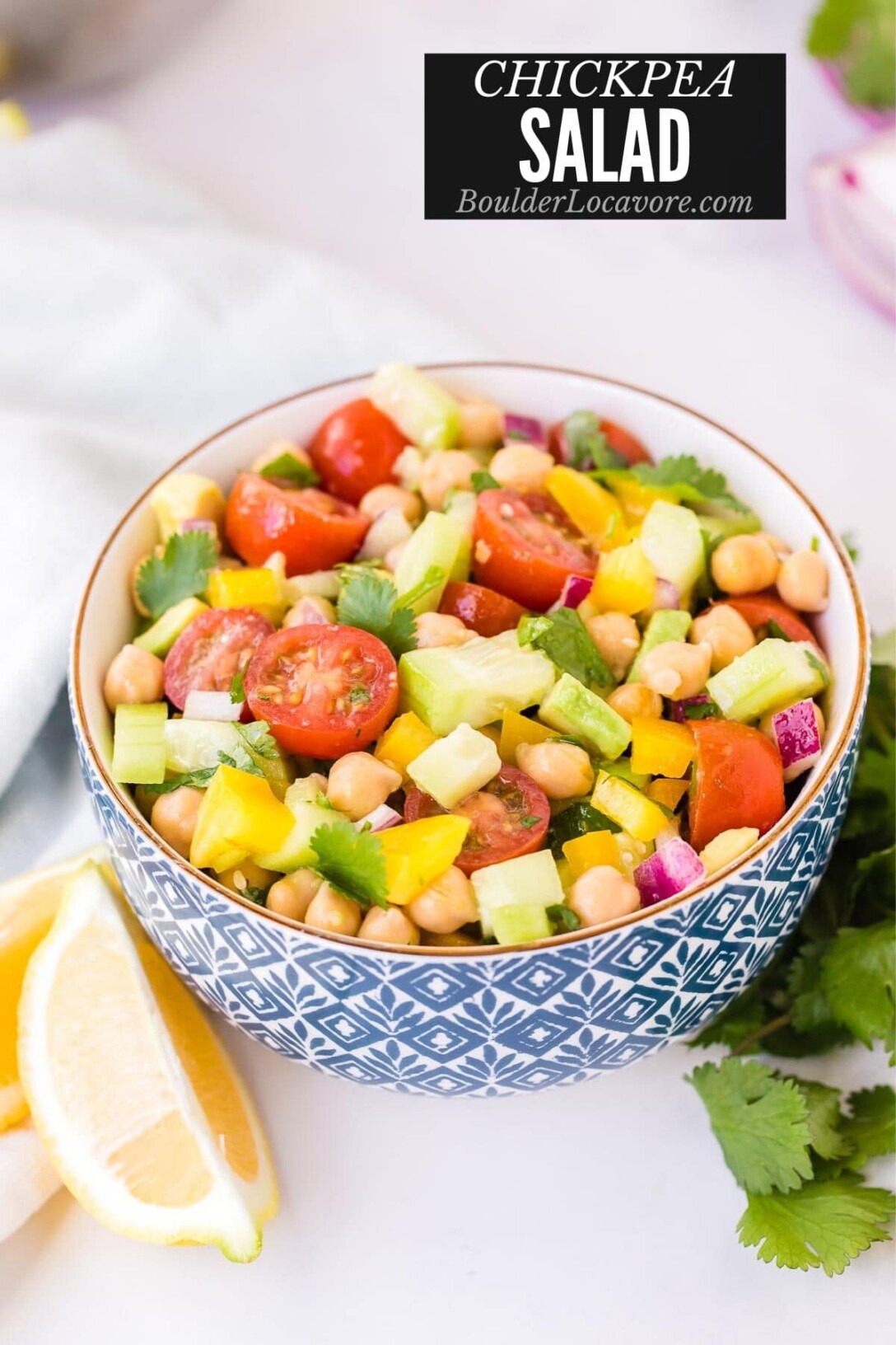 Chickpea Salad in a blue and white bowl with lemon wedges (title image)