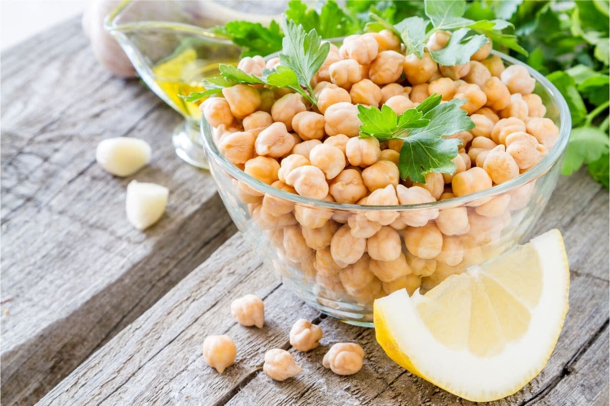 chickpeas in a bowl with lemon wedges