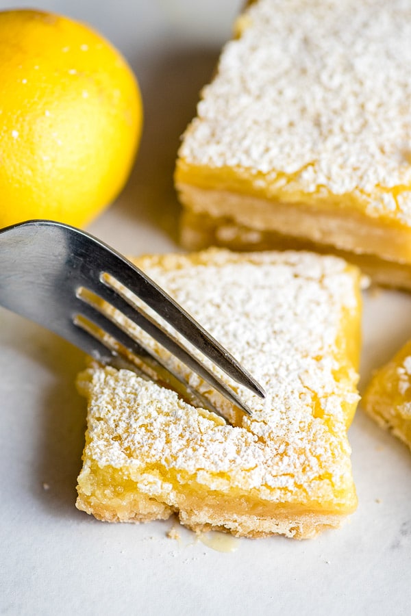 fork cutting into a lemon bar