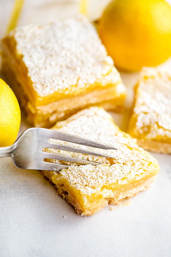 fork cutting into a lemon bar from top