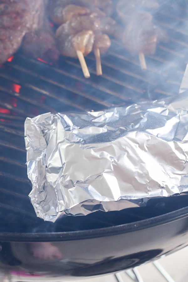 foil packets of grilled potatoes on a grill