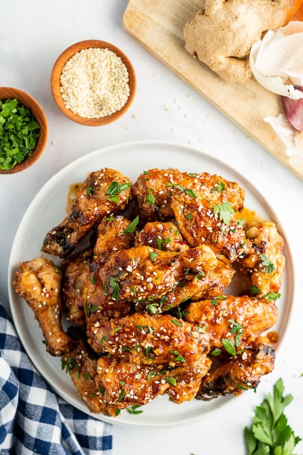 mound of sticky grilled chicken wings on a white plate 