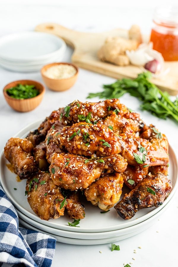 sticky grilled chicken wings on a white plate side view 