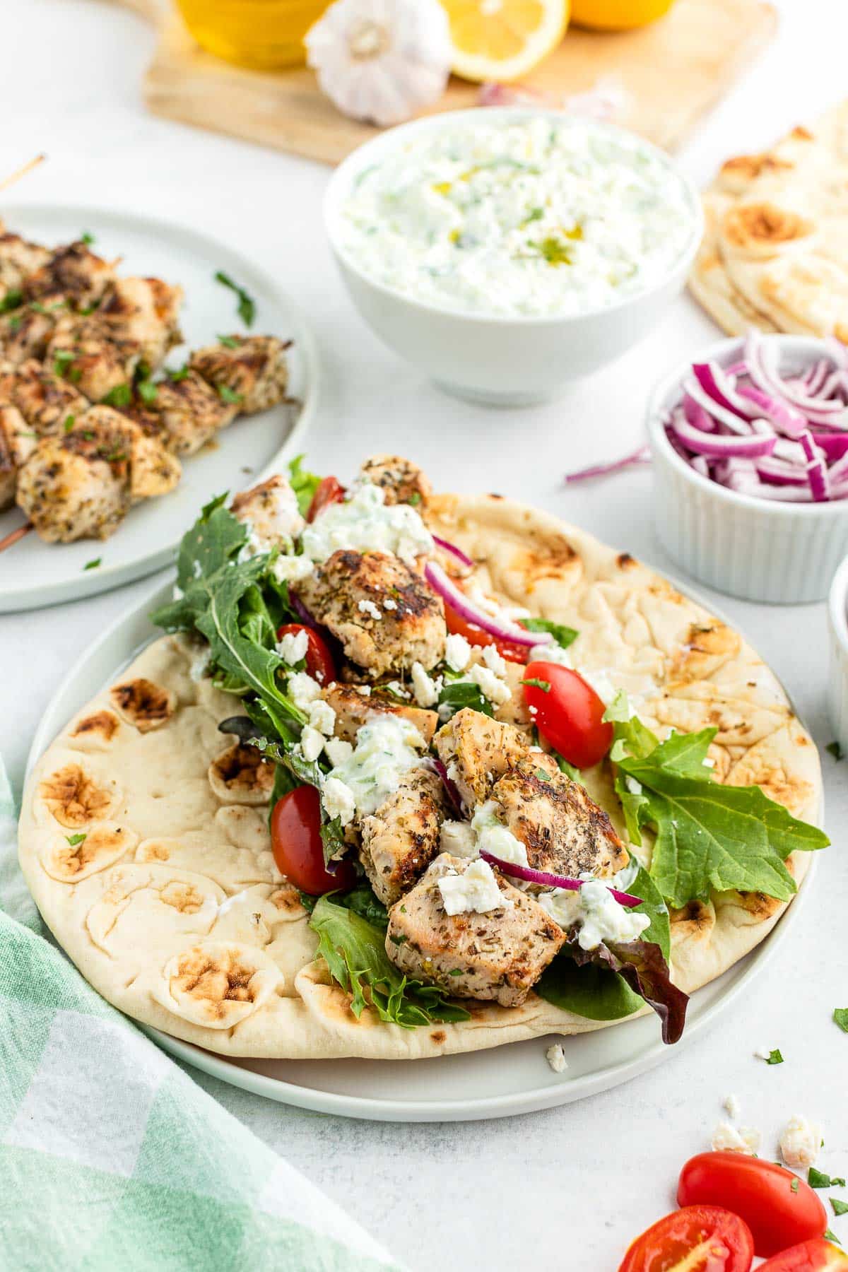 grilled chicken souvlaki, vegetables and feta cheese on soft flatbread
