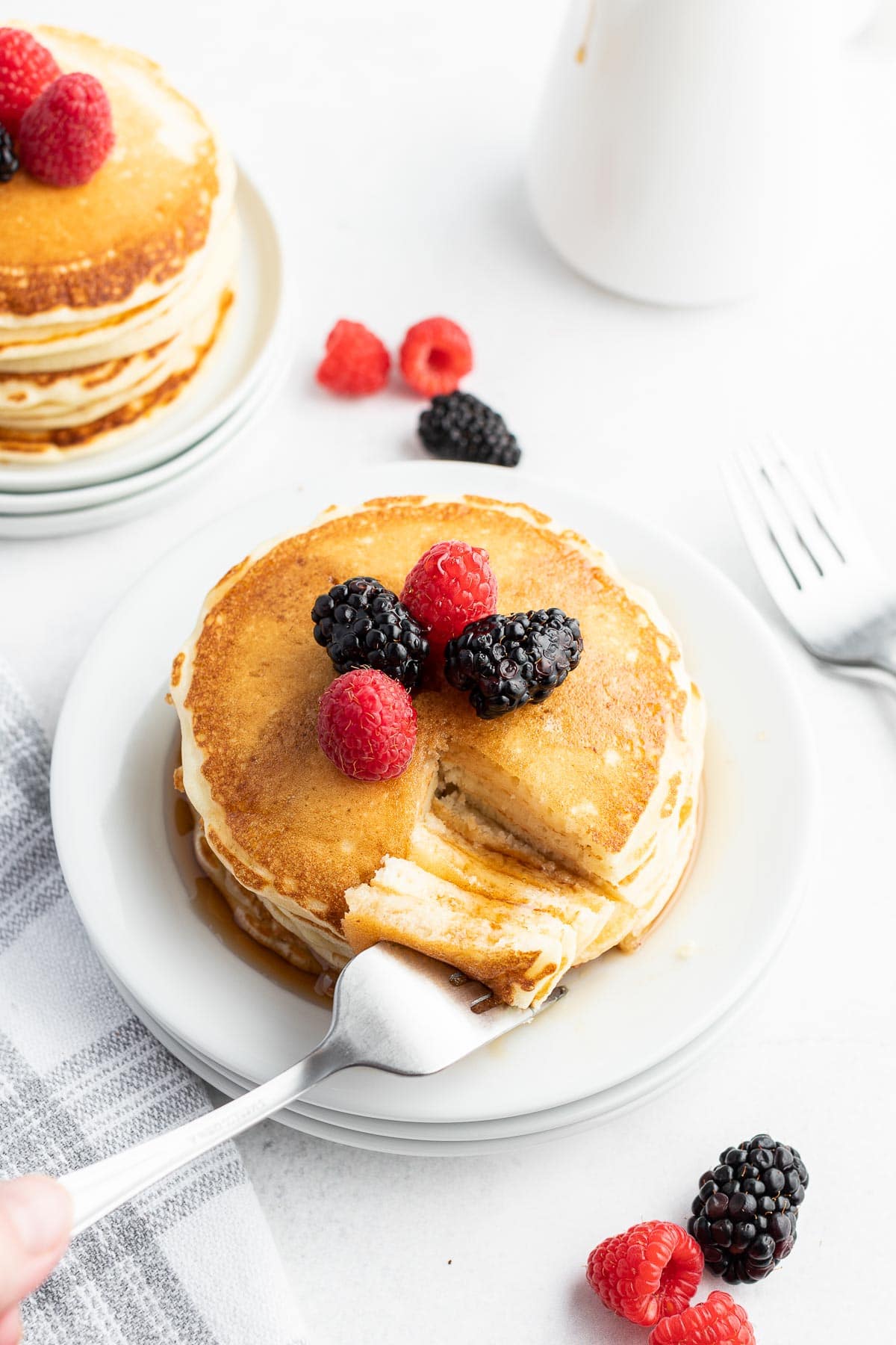 stack of buttermilk pancakes with a bite on a fork