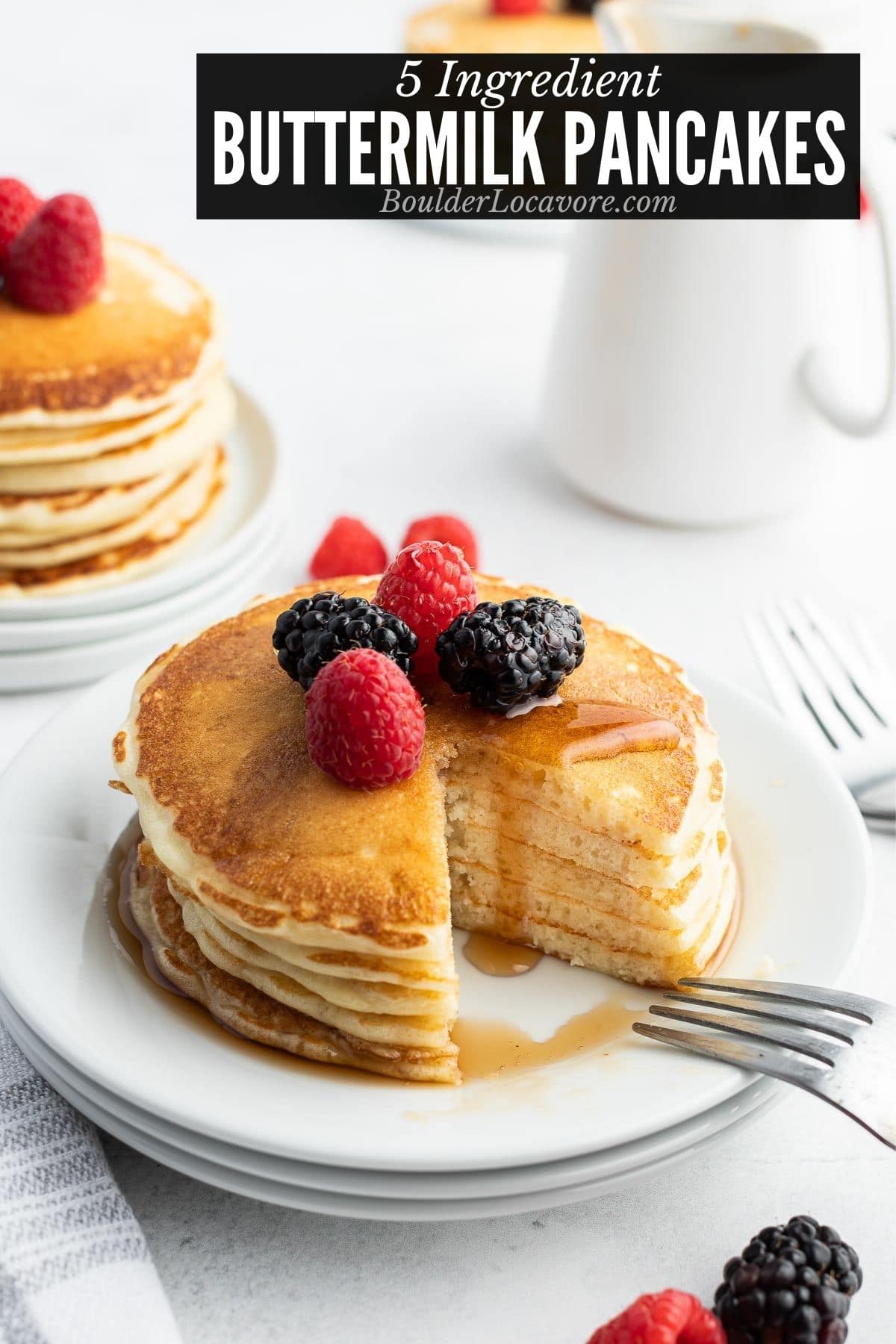stack of fluffy buttermilk pancakes on a white plate with wedge cut out