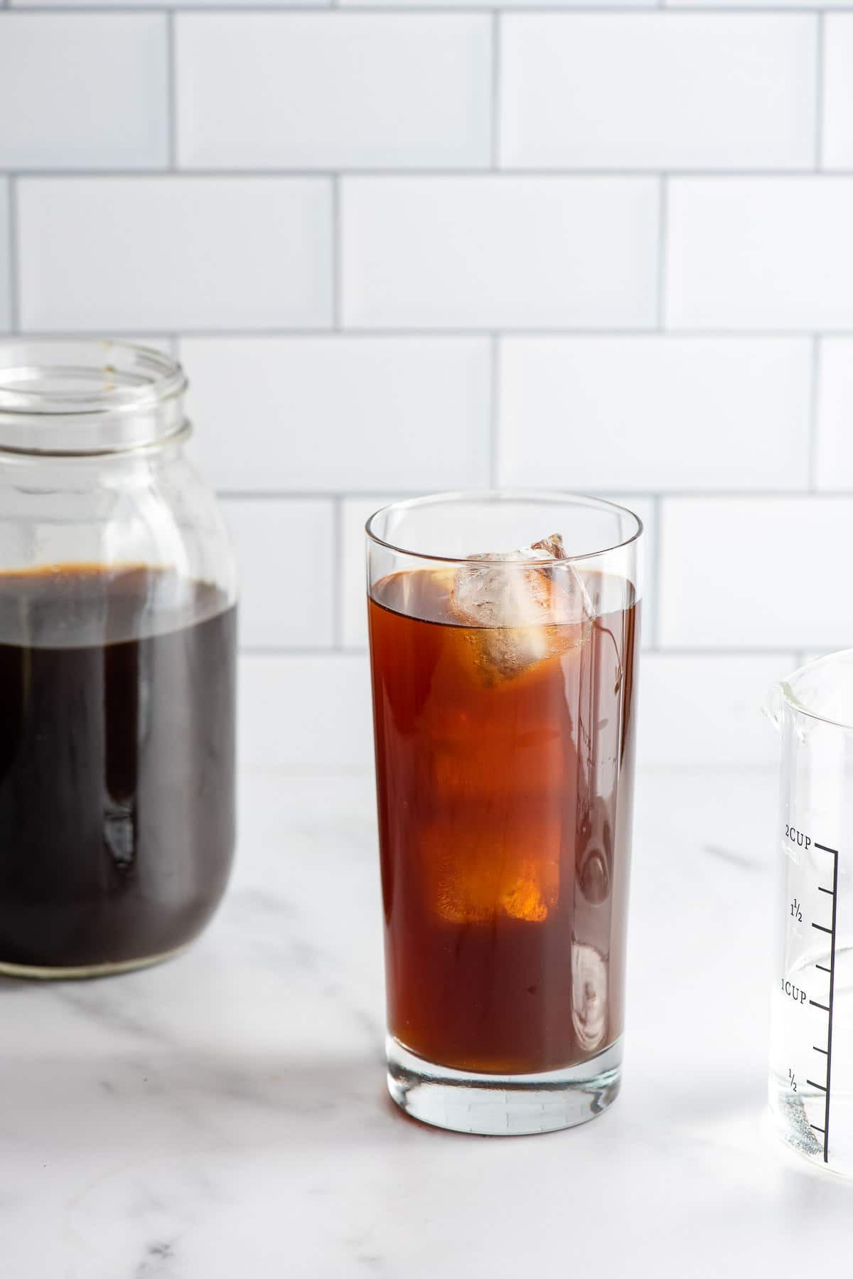 Cold Brew coffee concentrate and water in a tall glass with ice