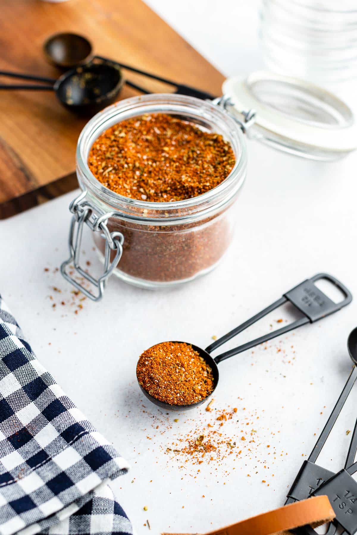 black measuring spoon with dry rub and spice jar in the background