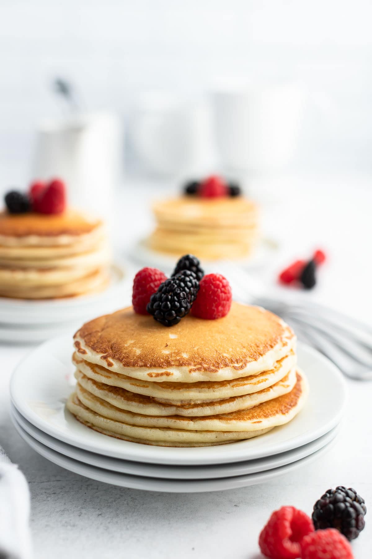 stack of buttermilk pancakes with berries on top