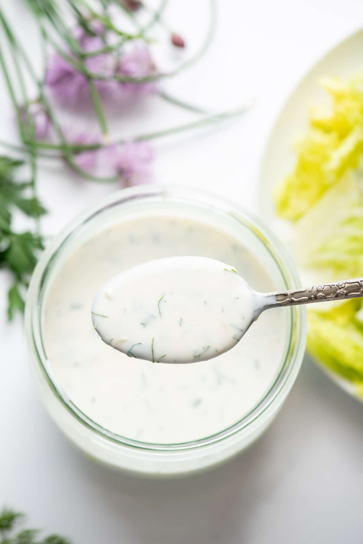 buttermilk ranch dressing in a glass jar and on a spoon