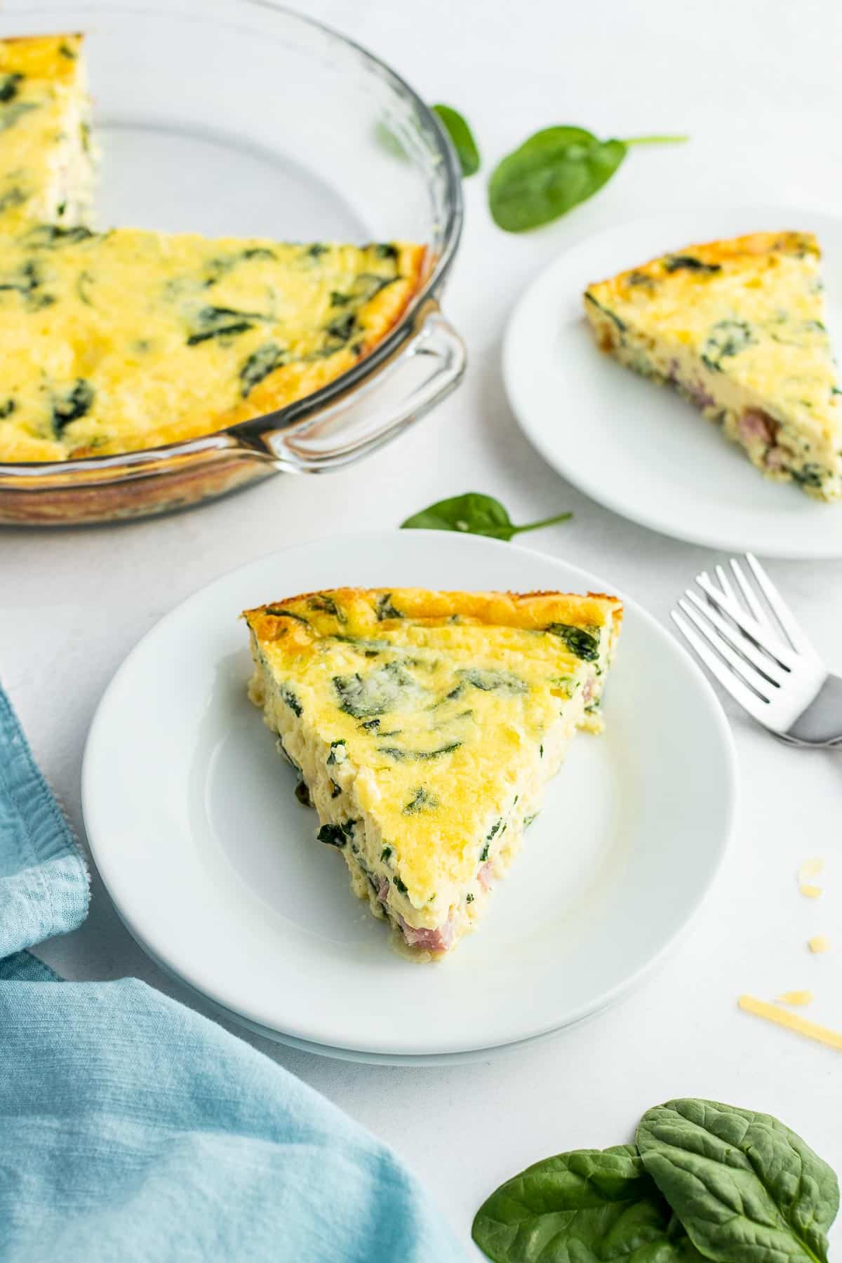 slices of ham and spinach quiche on white plates