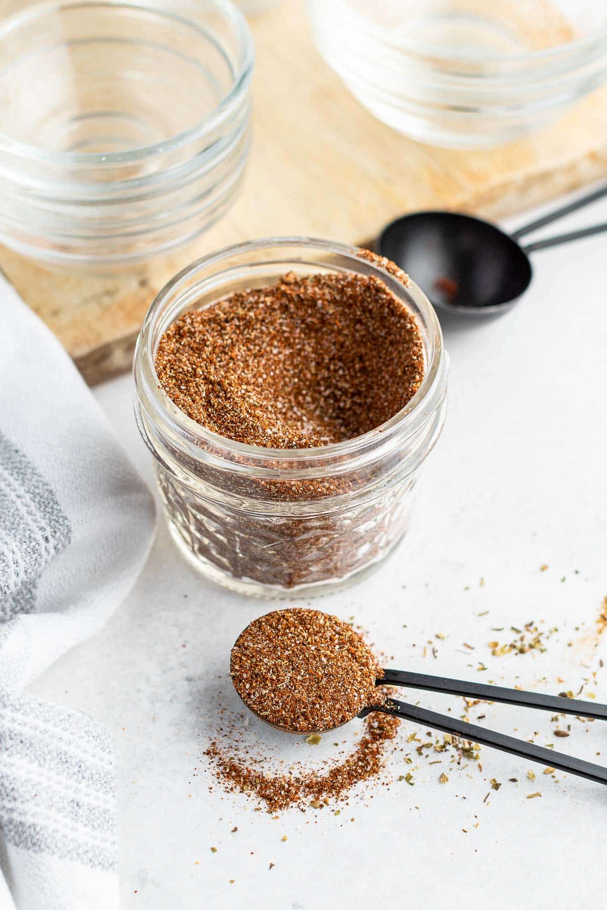 taco seasoning mixed in a jar with a tablespoon of the mix in foreground