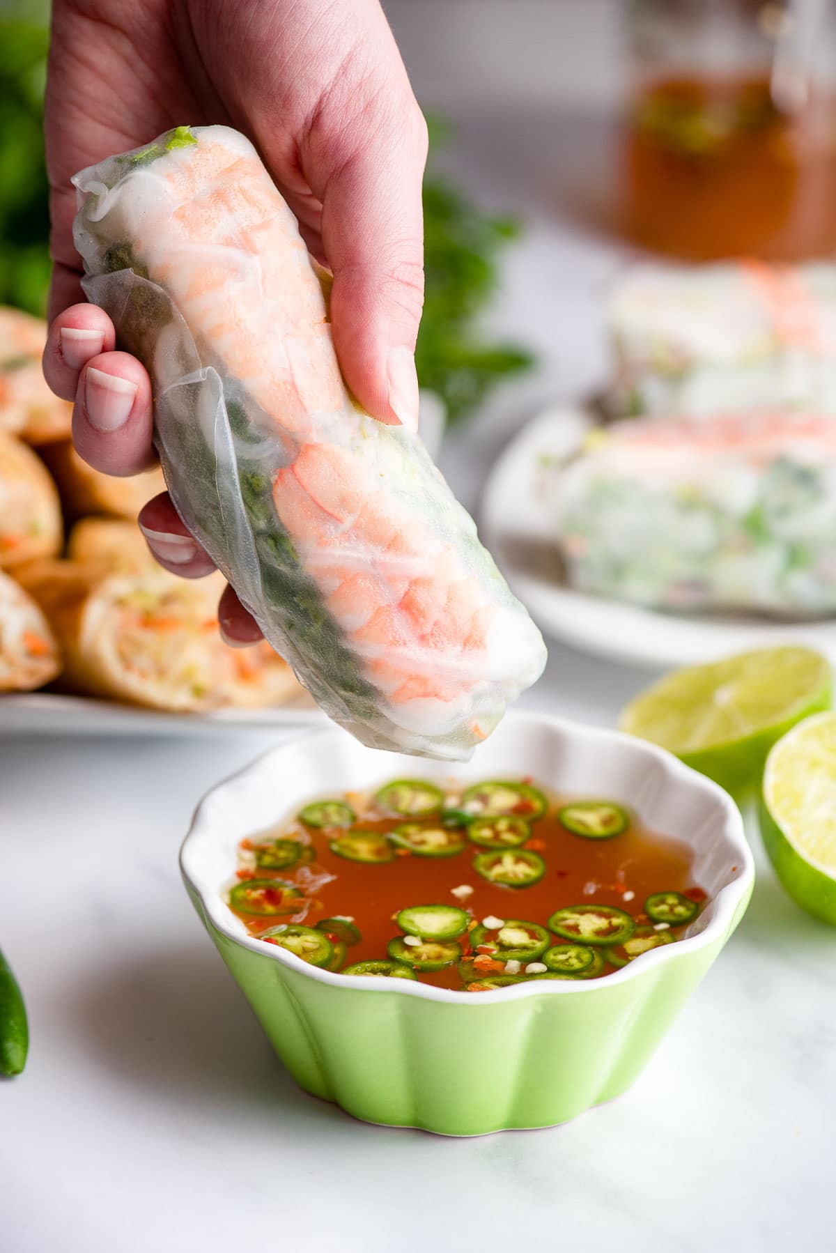 dipping shrimp spring roll in nuoc cham