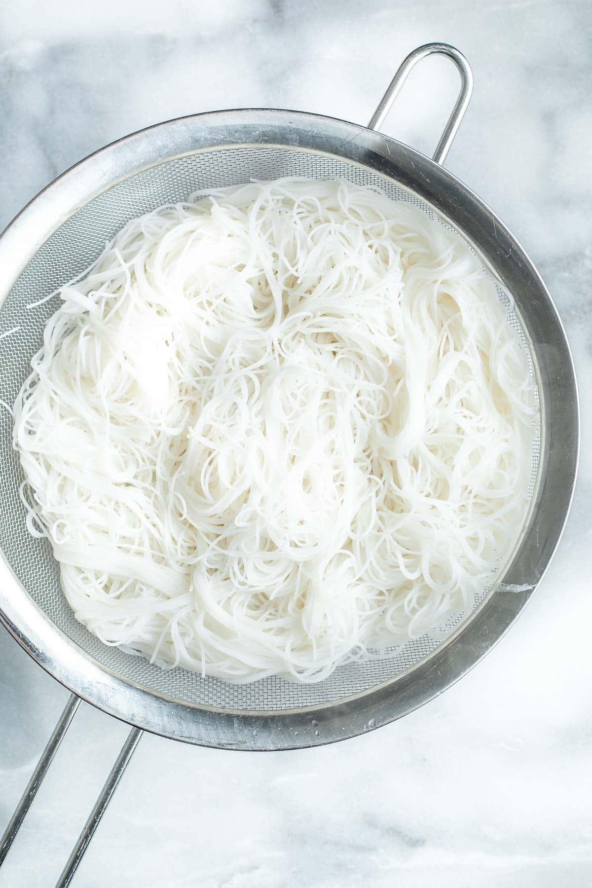 rinsed rice vermicelli noodles in strainer