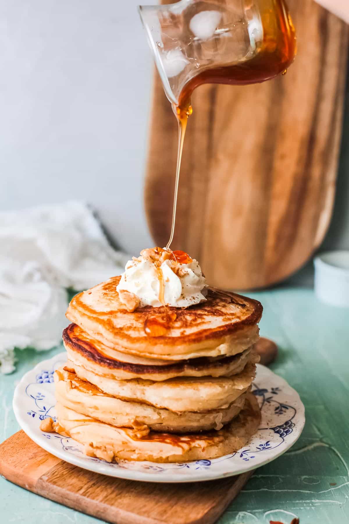 stack of eggnog pancakes with syrup pour