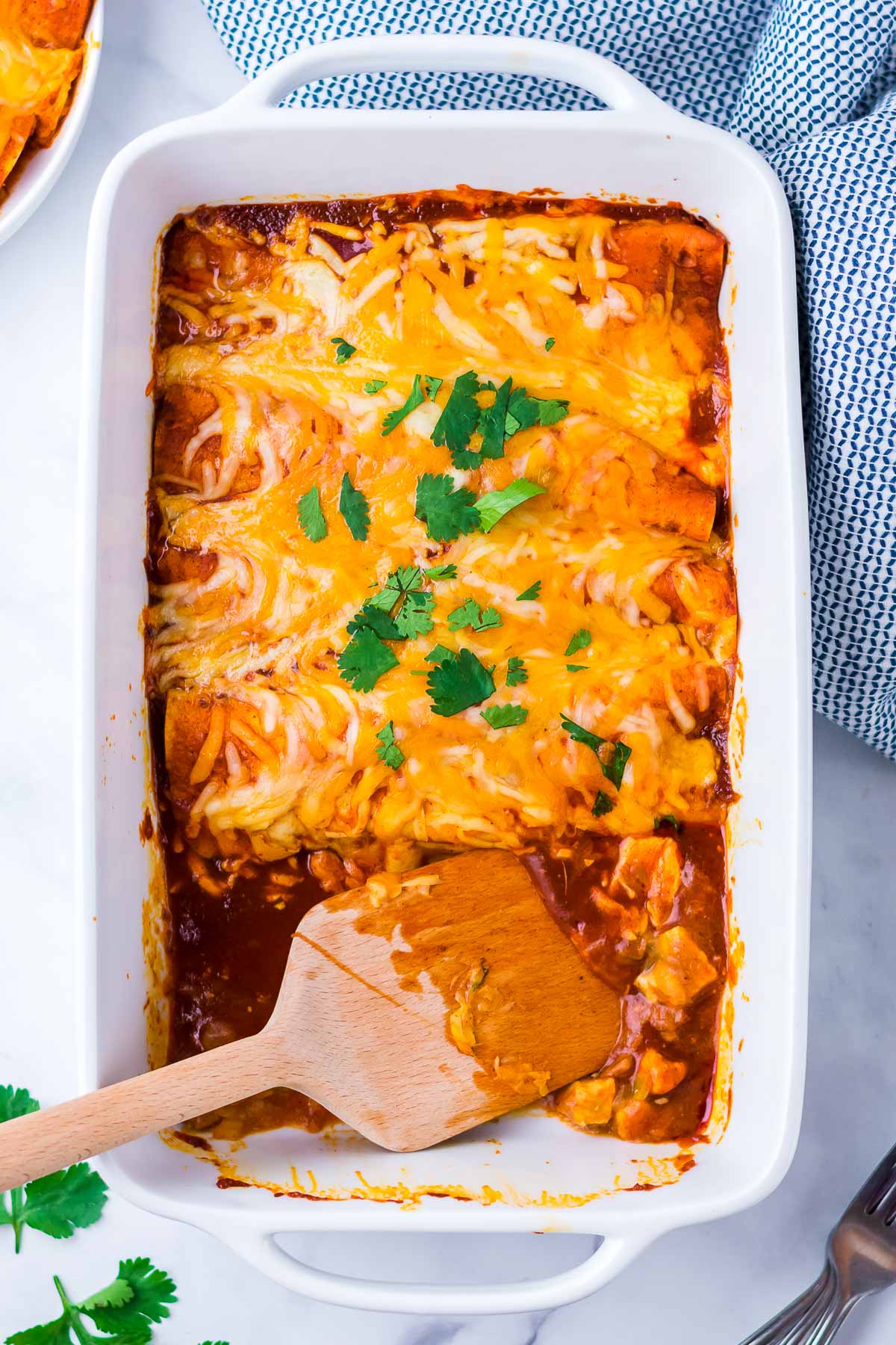 chicken enchiladas cooked in pan with spatula