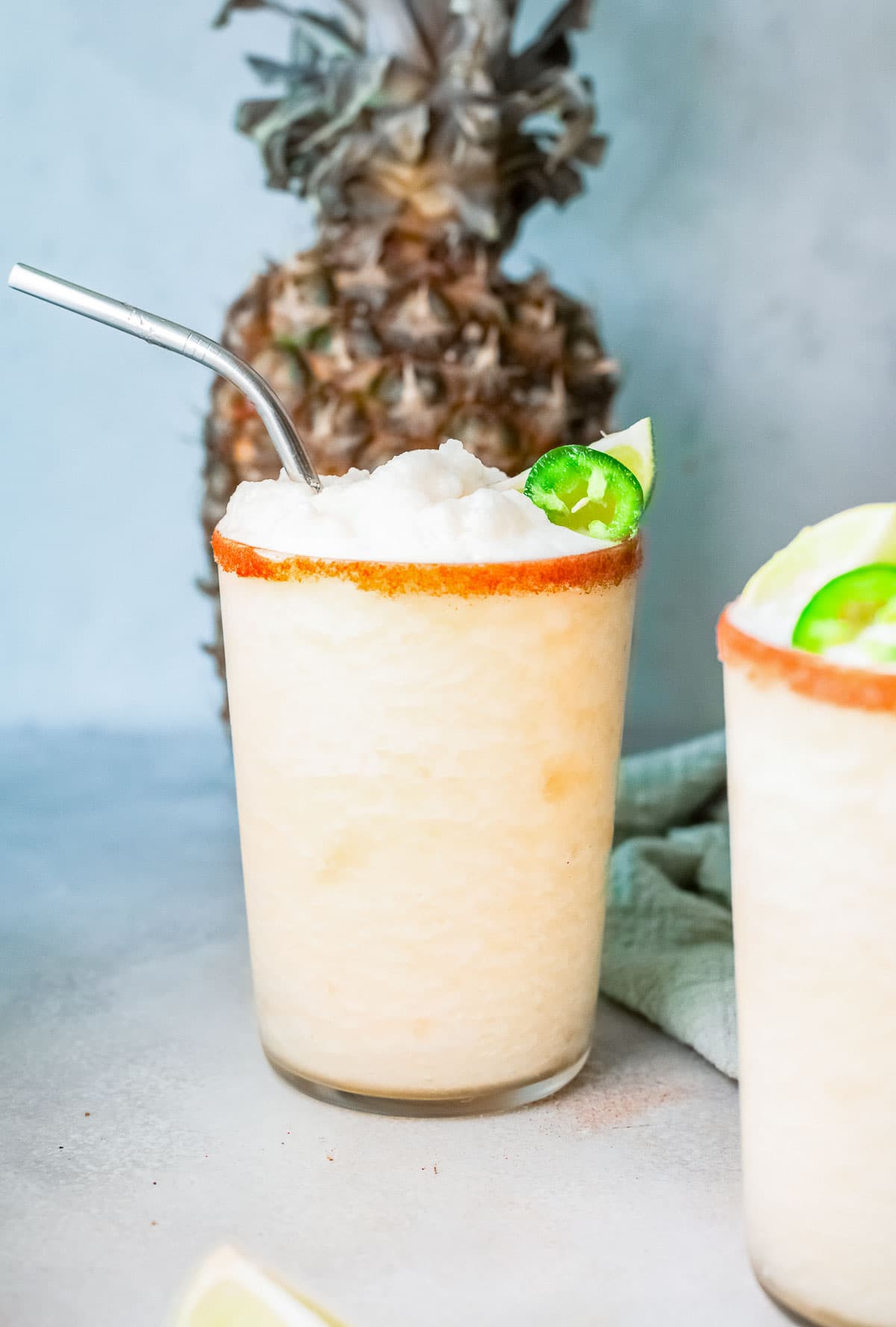 frozen pineapple margaritas in a rimmed glass side