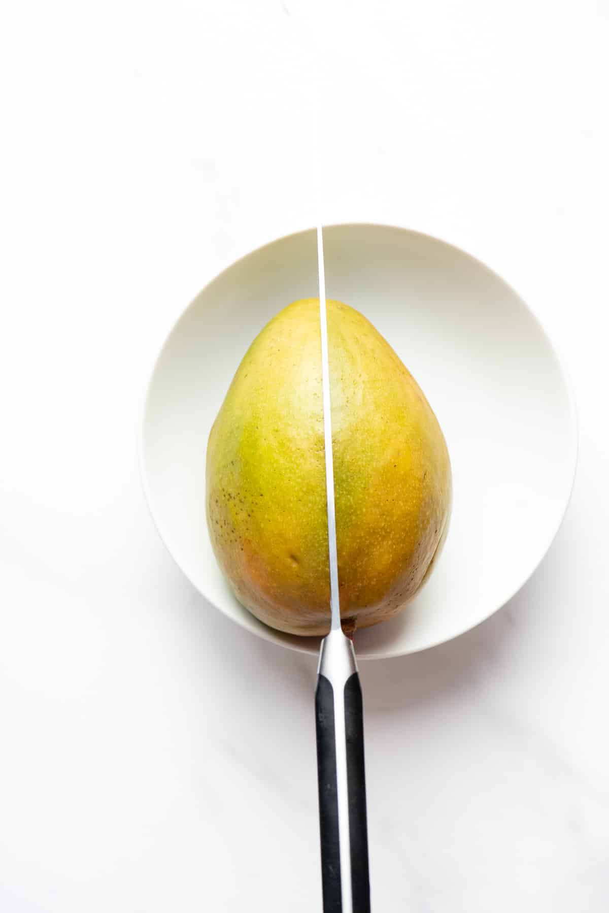 cutting a mango - knife in fruit