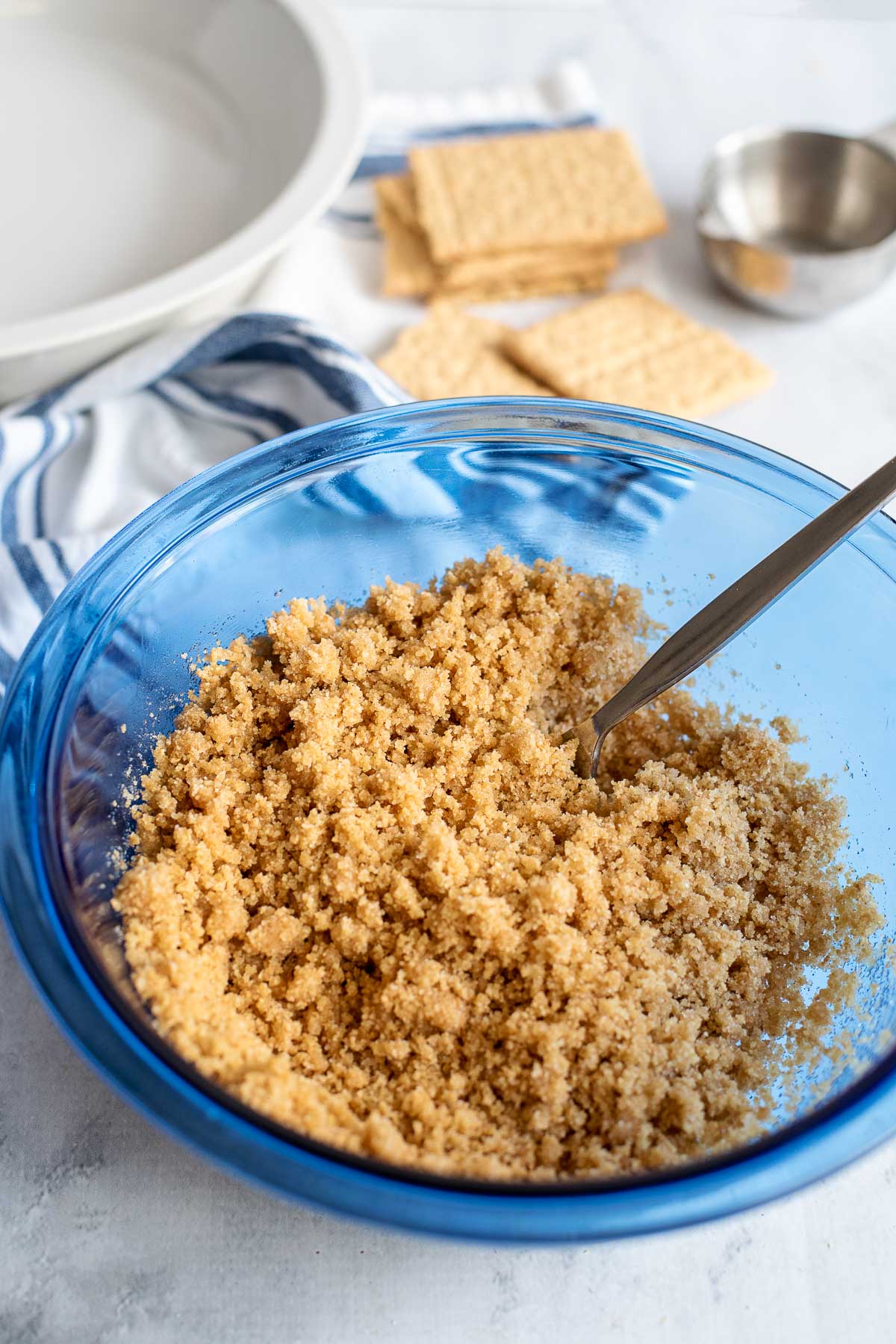 mixing graham cracker crumbs and melted butter