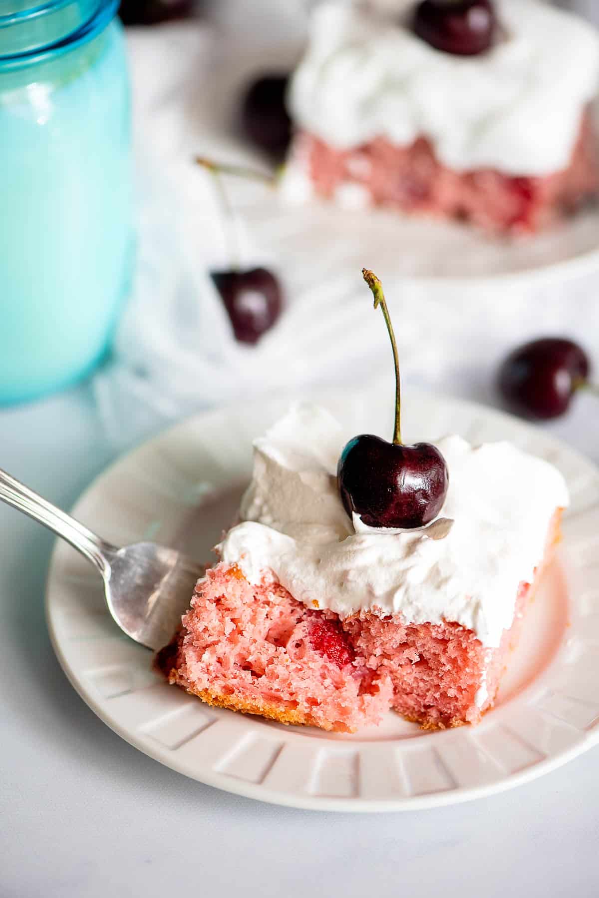 cherry cake slice with whipped cream with bite
