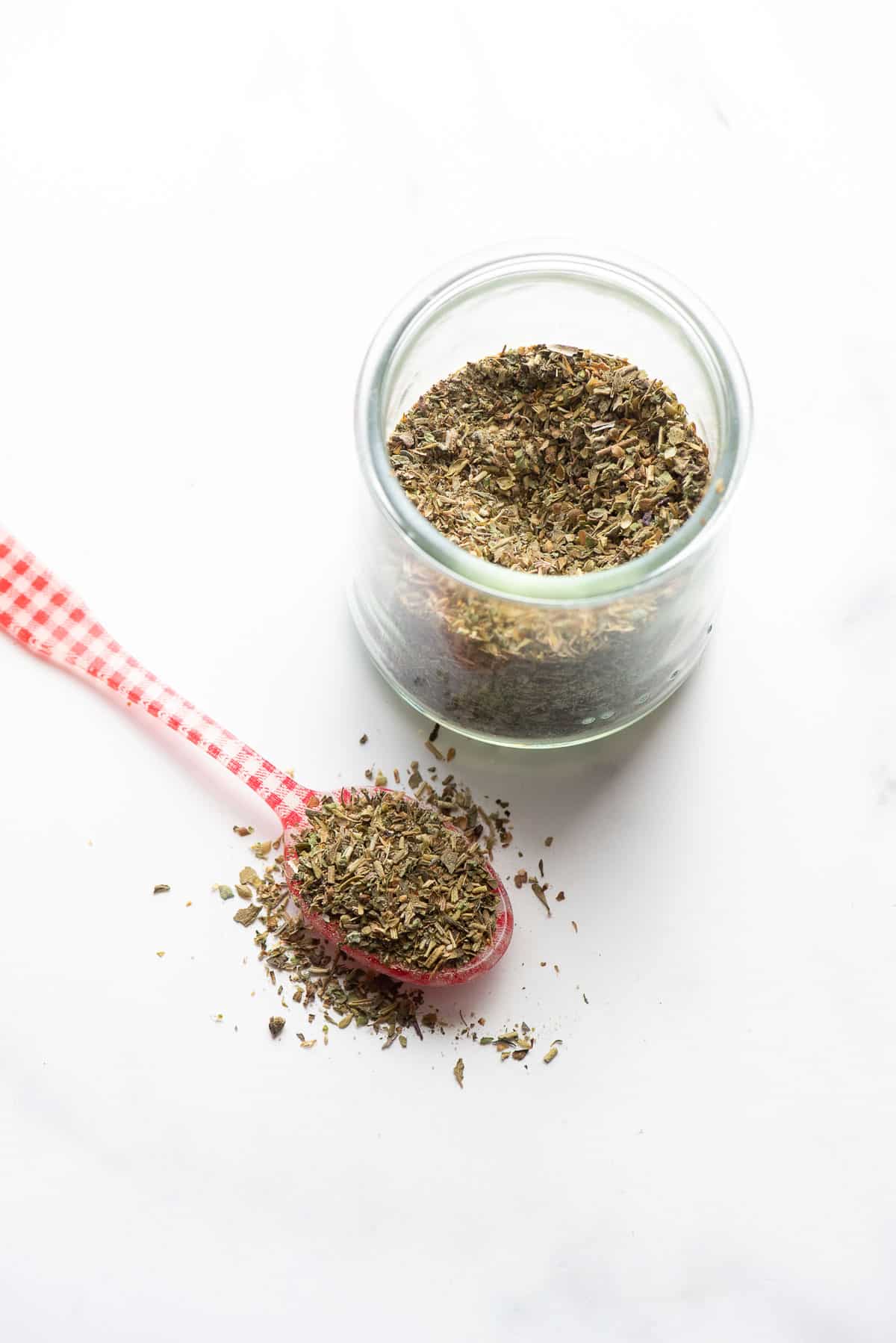 Italian seasoning in jar and on spoon