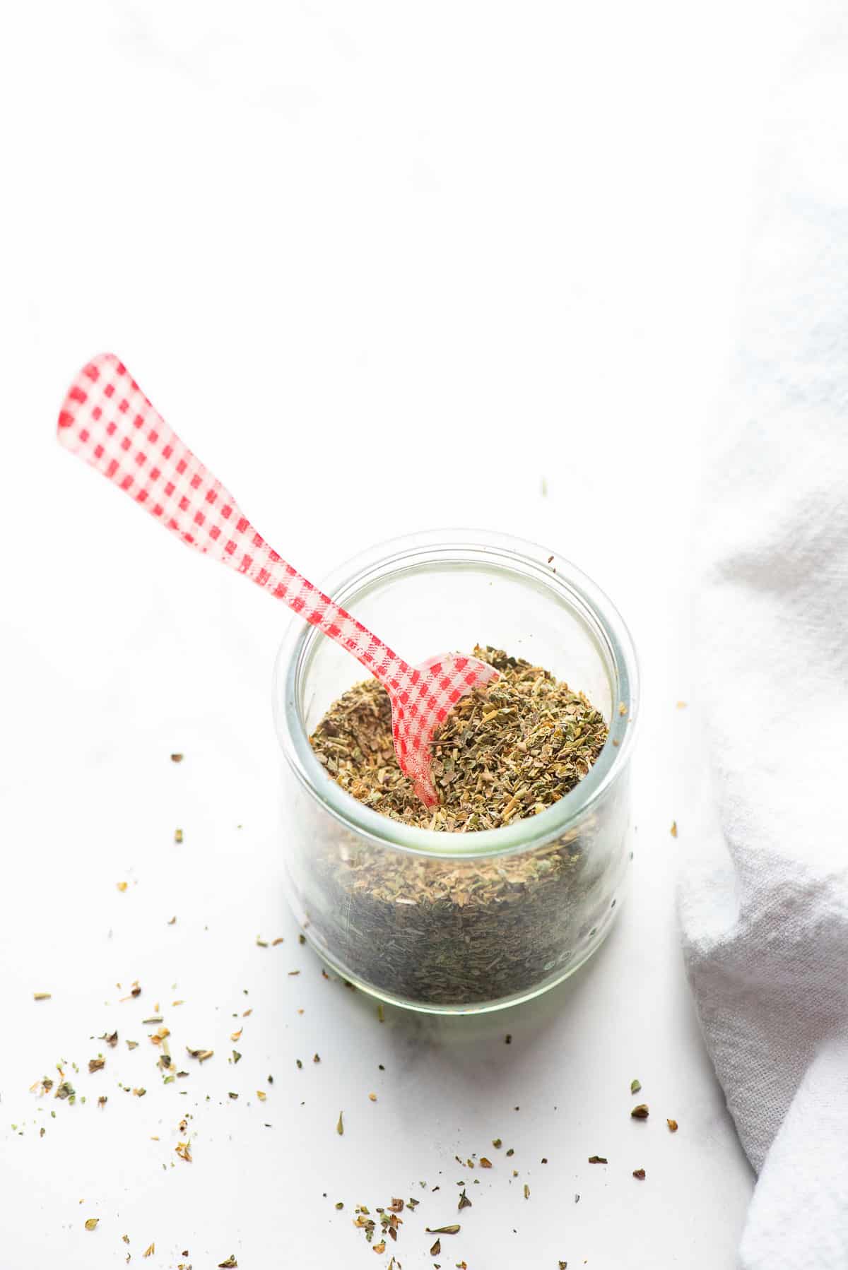 Italian seasoning in jar close up with spoon