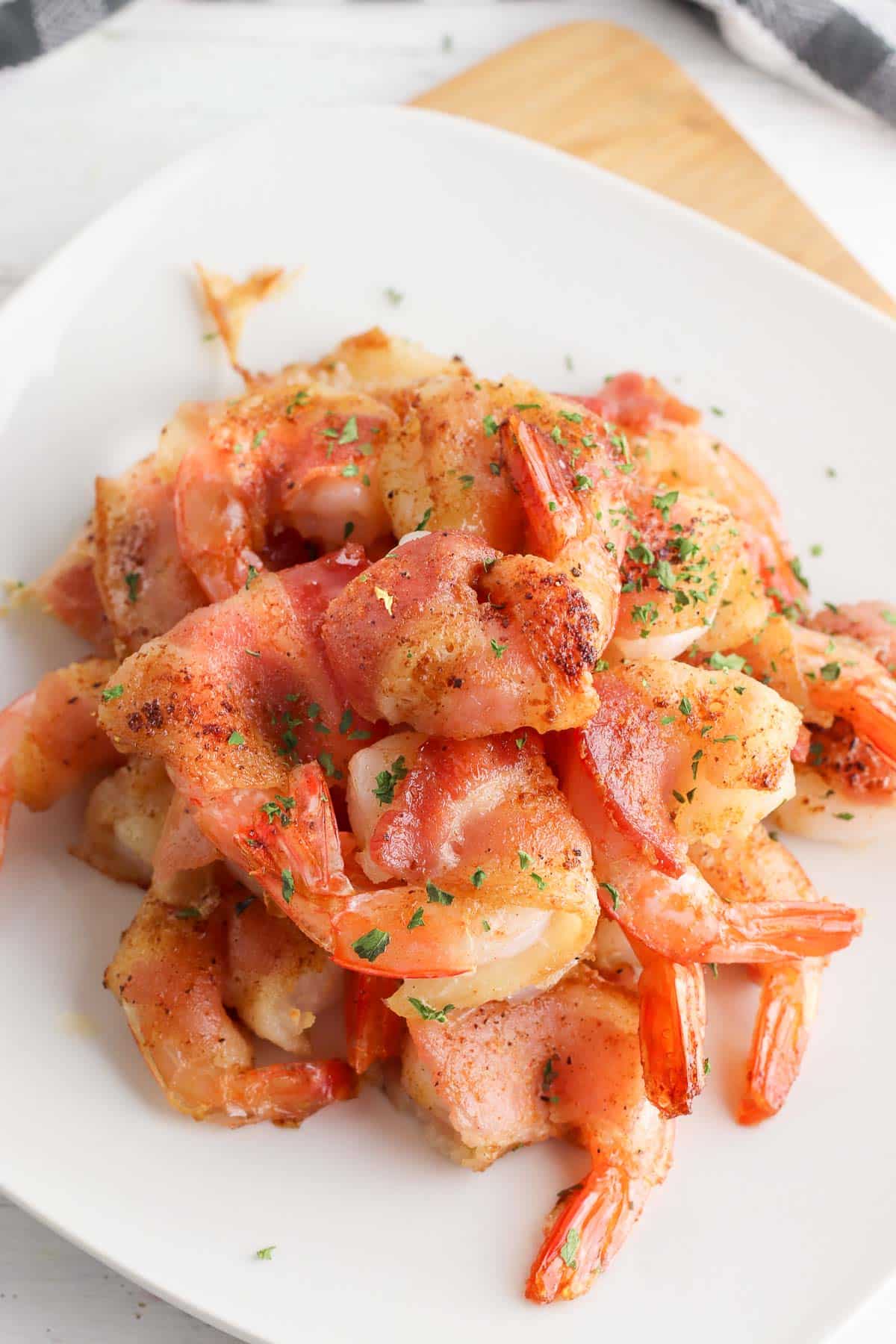 bacon wrapped shrimp on a white plate 